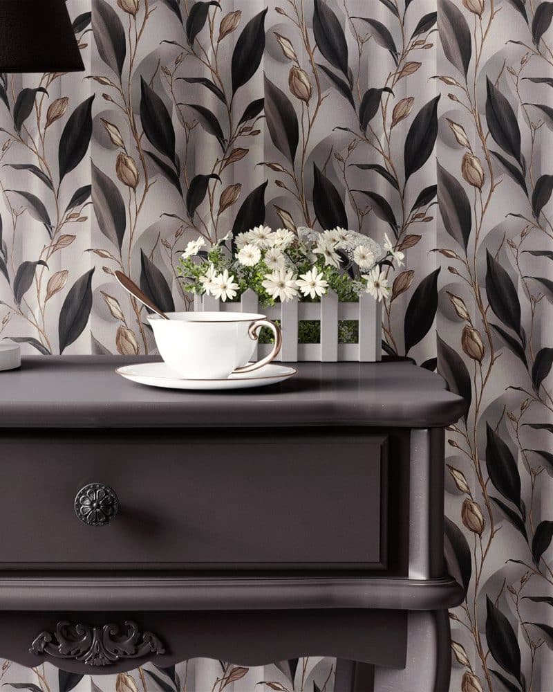 Dark wooden nightstand with a teacup and saucer, and a small white planter of white flowers on top.