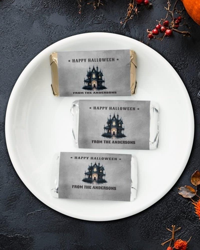 Three Halloween chocolate bars on a plate. Each wrapper features a haunted house illustration and a personalized message.