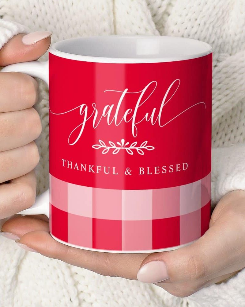 A person's hands holding a red coffee mug that says grateful, thankful, and blessed.