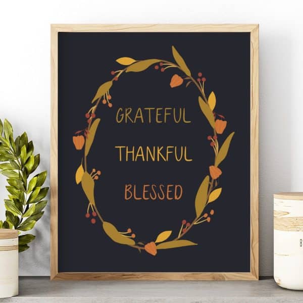 Framed Print With A Dark Background Featuring A Fall-Themed Floral Wreath Surrounding The Words Grateful, Thankful, And Blessed.