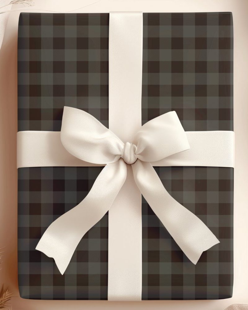A dark gray and black plaid gift box with a large cream-colored bow.