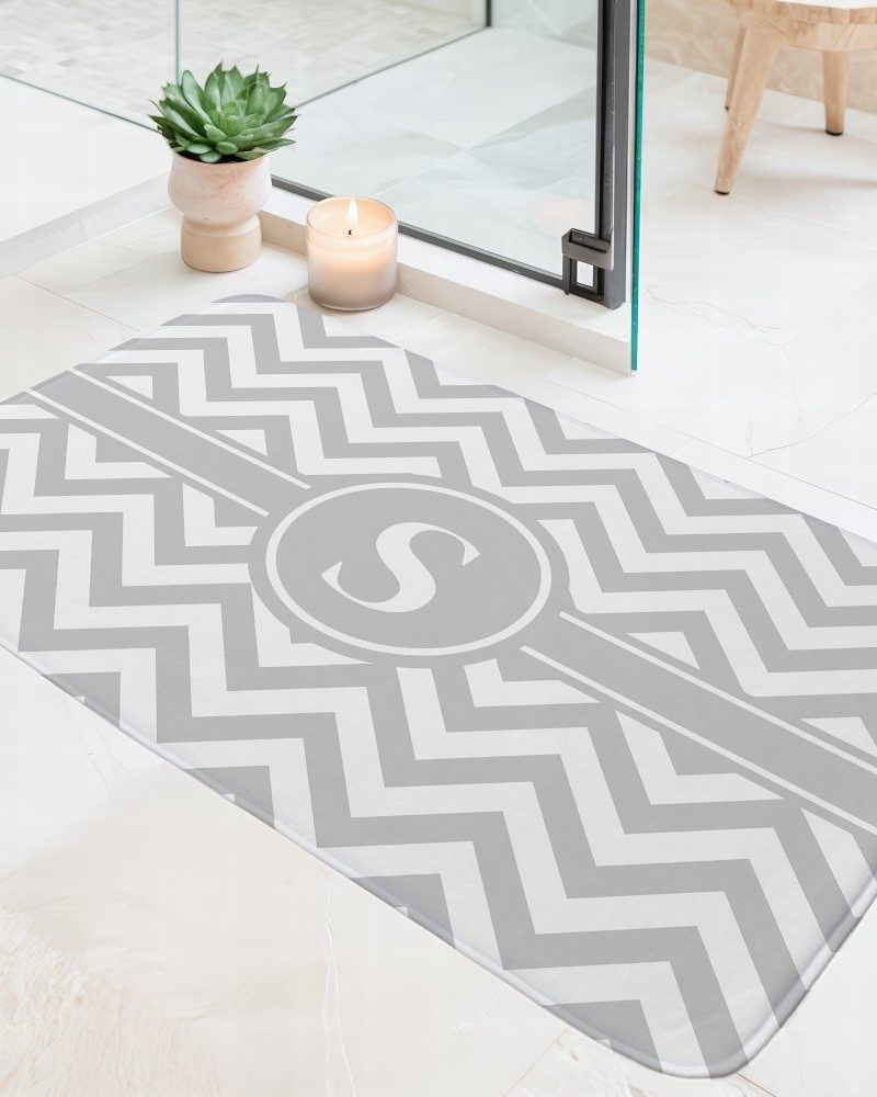 Grey chevron bath mat with a centered monogrammed S.