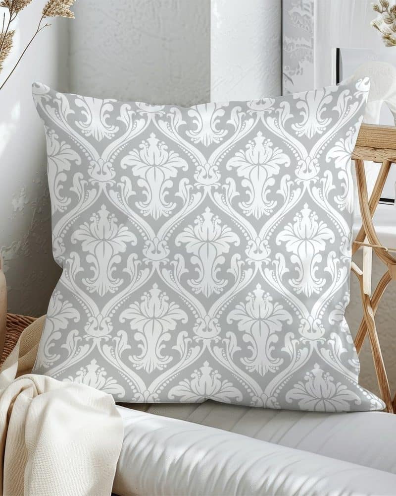 Grey throw pillow with a white damask pattern.
