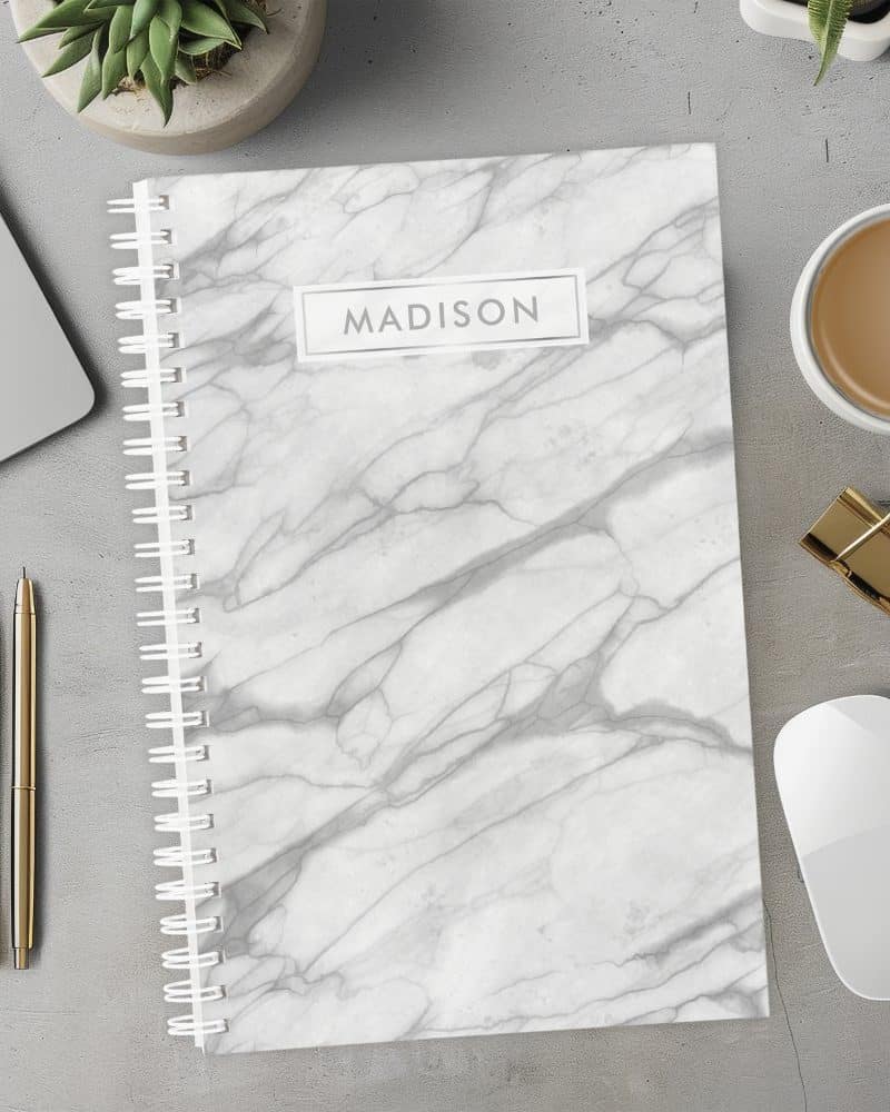 Spiral-bound notebook with a gray marble design and the name Madison on the cover.
