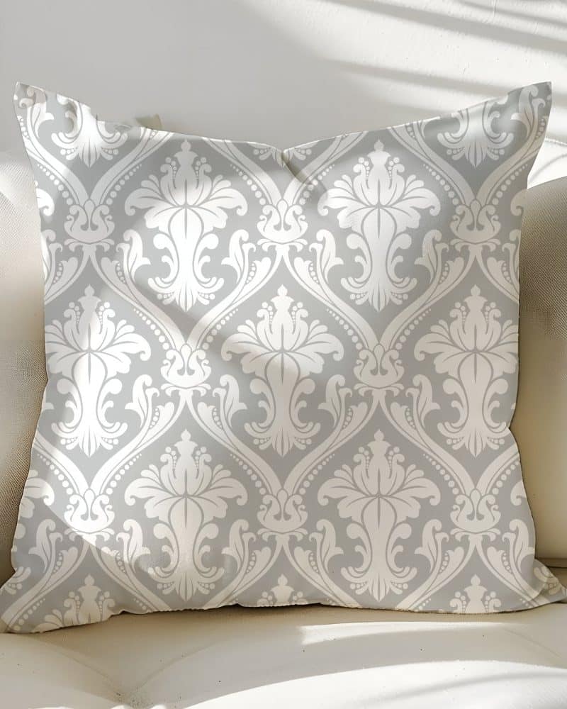 Gray throw pillow with a white damask pattern.