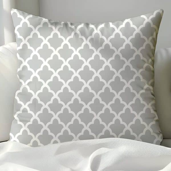 Gray Throw Pillow With A Repeating White Geometric Pattern.