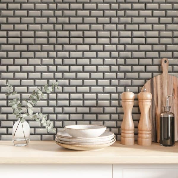 Stack Of Dishes And Kitchen Utensils In Front Of A Grey Subway Tile Backsplash.