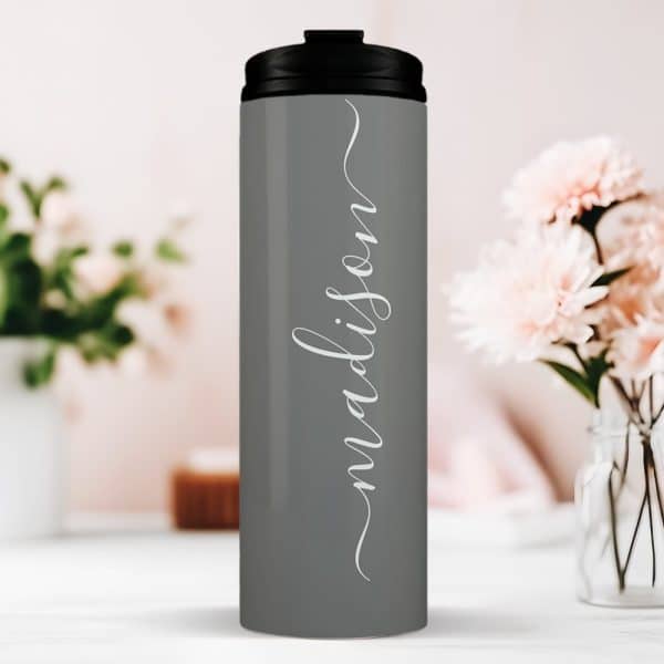 Gray Travel Tumbler With The Name Madison In A White Script Font.