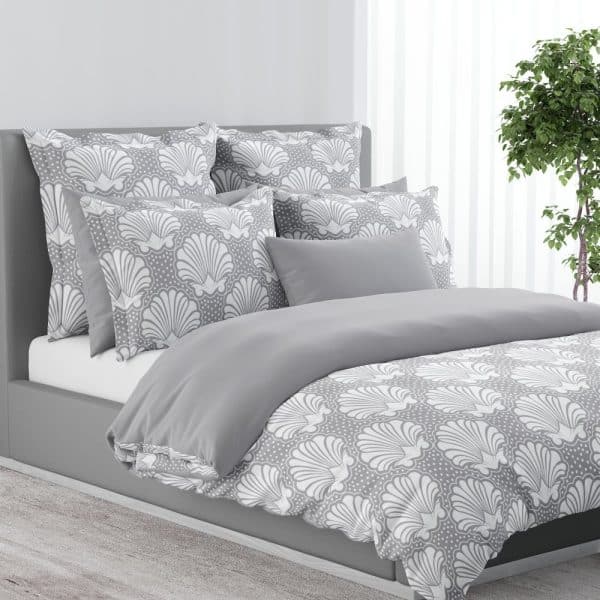 Gray Bed With A Duvet Cover And Pillows Featuring A White Seashell Pattern.