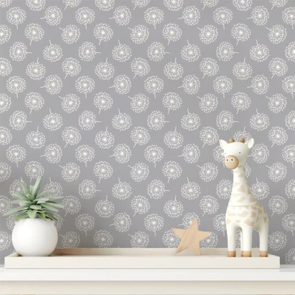 Grey Wallpaper With A Repeating Pattern Of White Dandelions. A Small Wooden Giraffe And Star Sit On A Shelf In Front Of The Wallpaper.