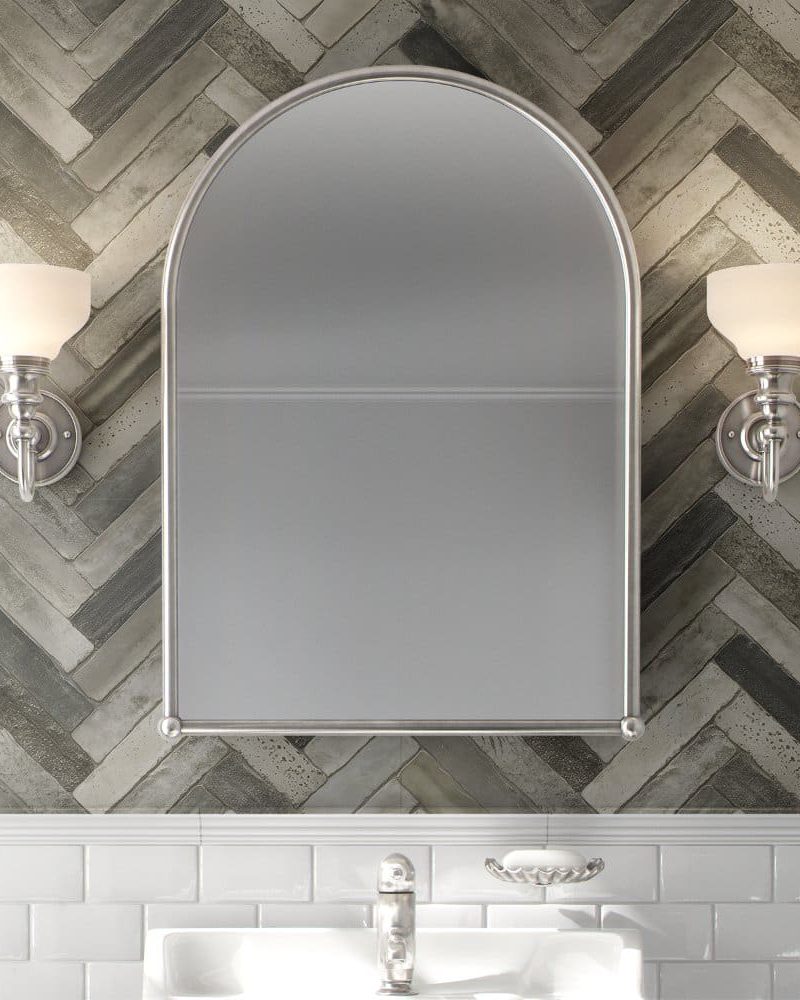 Arch-shaped medicine cabinet with flanking wall lights above a bathroom sink.