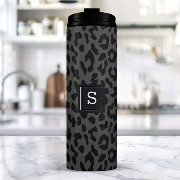 Gray And Black Leopard Print Travel Tumbler With A White Letter S In A Square.