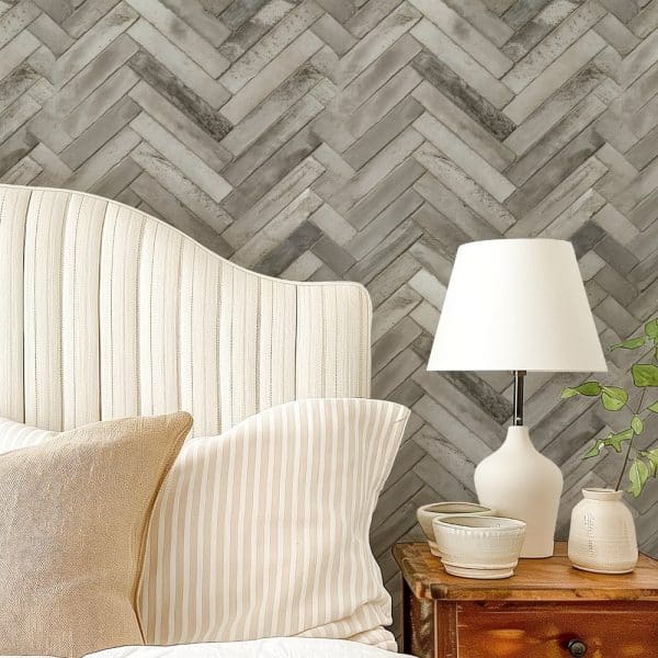 A Beige Striped Headboard With Matching Pillows Sits Against A Herringbone Patterned Wall.