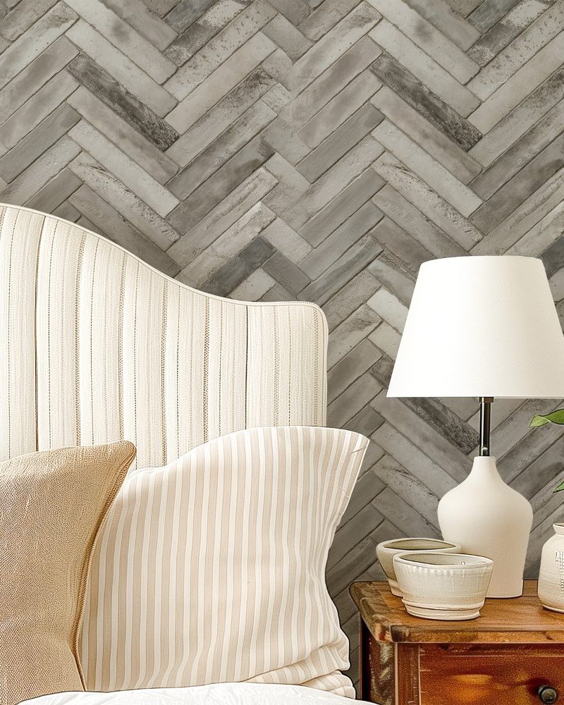 A beige striped headboard with matching pillows sits against a herringbone patterned wall.