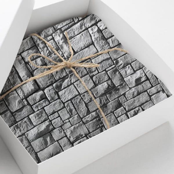 A Gray Stone-Patterned Gift Is Tied With Twine In A White Box.