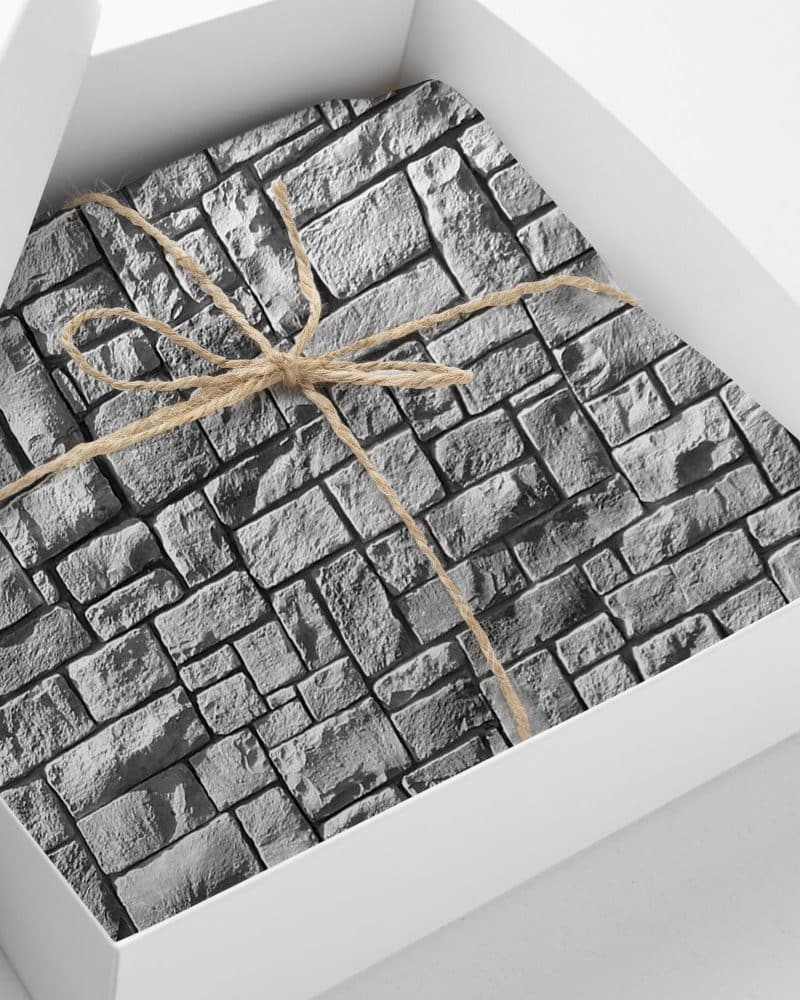A gray stone-patterned gift is tied with twine in a white box.