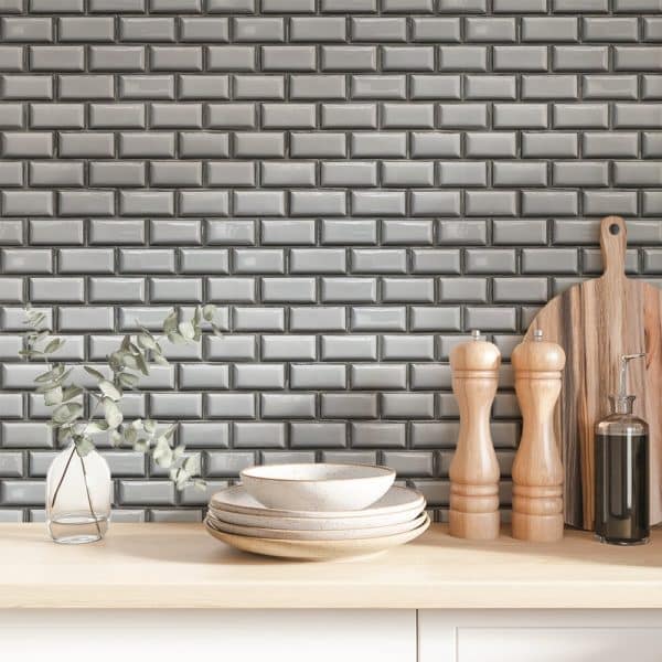 Grey Subway Tile Backsplash With Stacked Bowls And Kitchen Utensils On A Light Wood Counter.