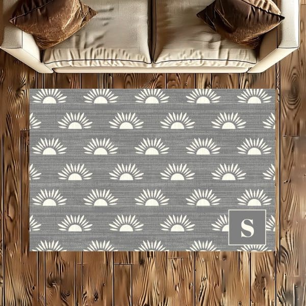 Gray Rug With A Repeating Pattern Of Off-White Suns And A Monogrammed S In The Corner.