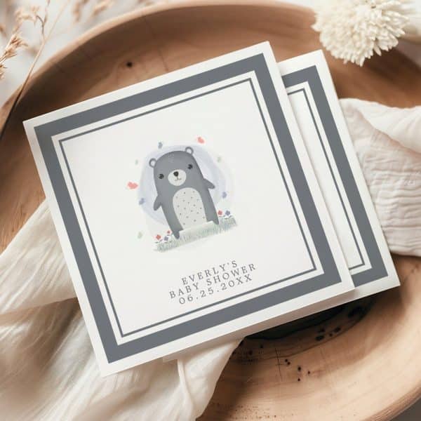 Baby Shower Invitation Featuring A Gray Bear Cub In A Field Of Flowers.