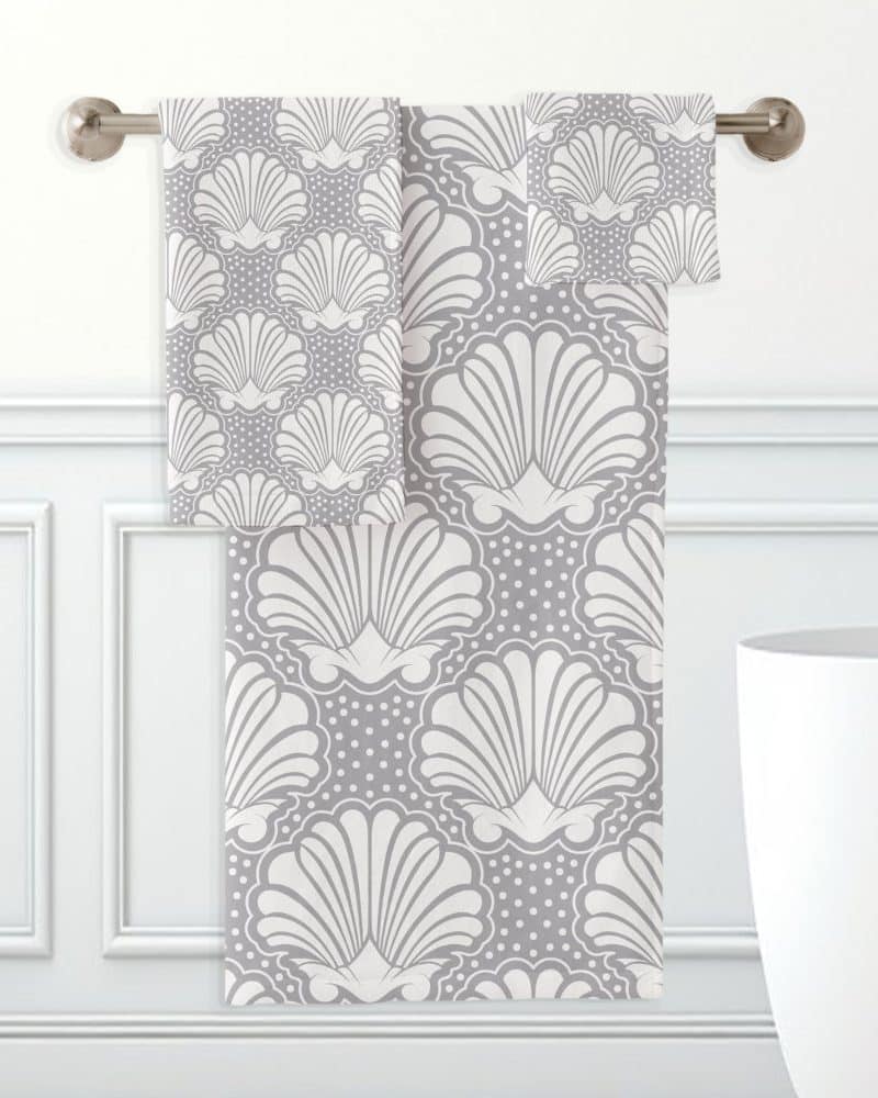 Gray and white bath towels with a seashell pattern.