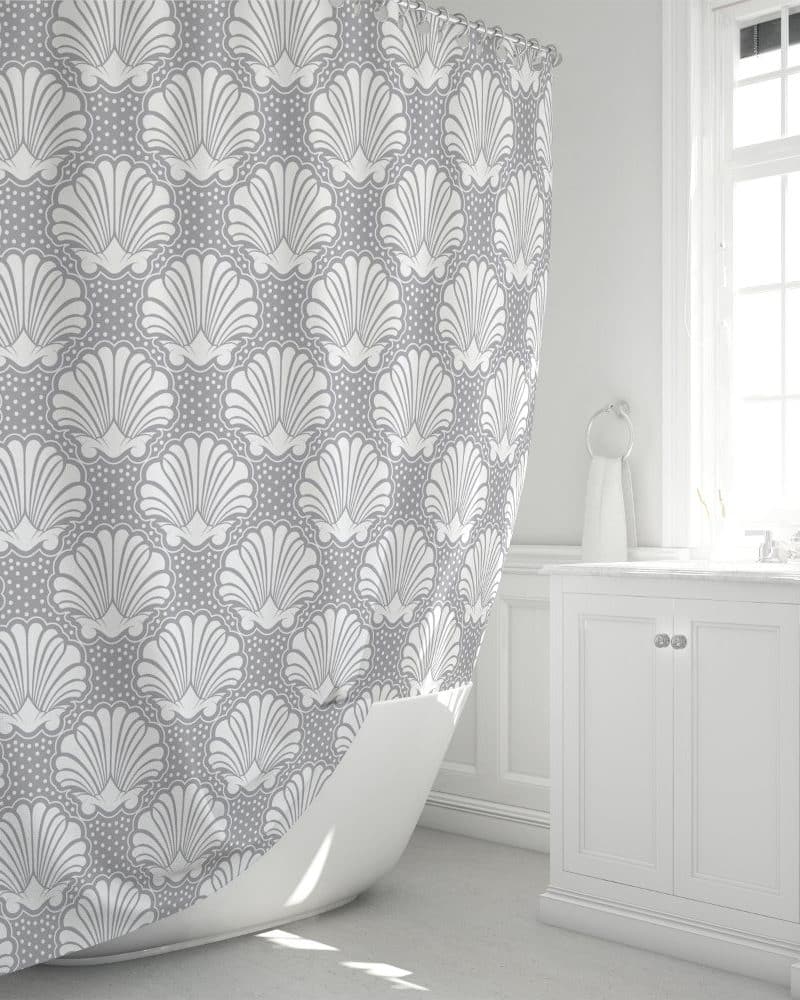 Gray shower curtain with a repeating pattern of white stylized seashells.