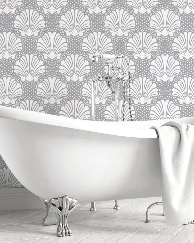 White clawfoot bathtub against a gray seashell patterned wall.