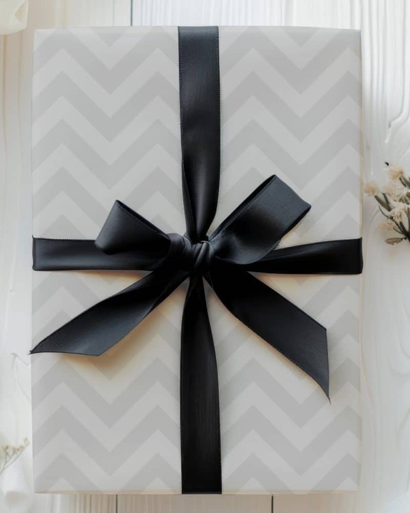 A gift box with a chevron pattern and a black ribbon.