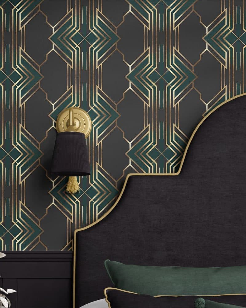 Dark headboard with gold trim against a wall with art deco wallpaper in teal and gold.