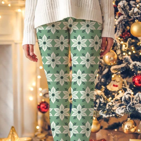 Sage Green Leggings With A Repeating Cream Poinsettia Pattern.
