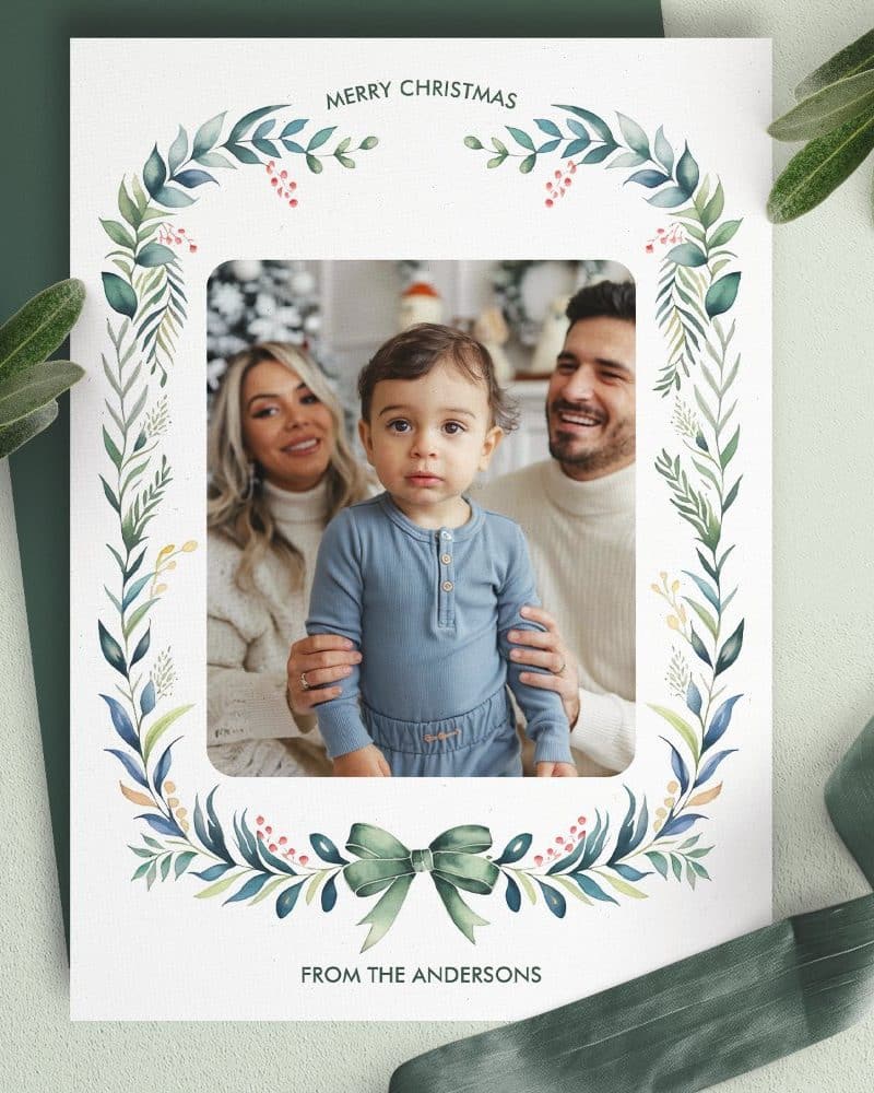 Christmas card featuring a family photo framed by a watercolor wreath. The Andersons are pictured.
