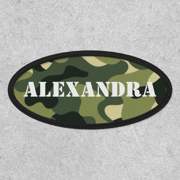 Oval Camouflage Patch With The Name Alexandra In White Lettering.