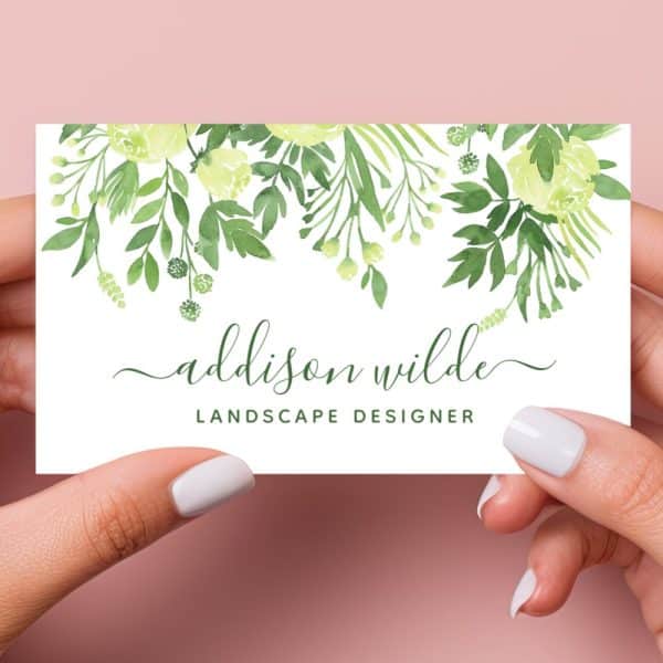 Two Hands Hold A Landscape Designer'S Business Card Featuring A Watercolor Floral Design In Shades Of Green And Yellow.