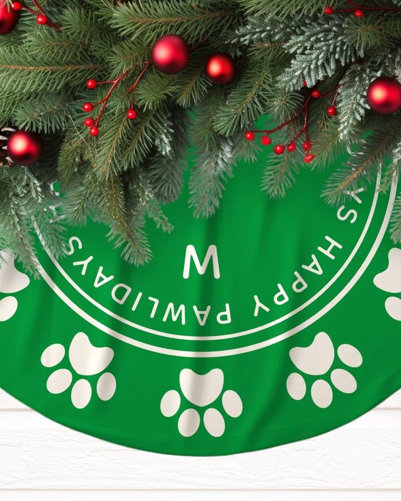 Green Christmas tree skirt with paw prints and the text Happy Pawlidays.