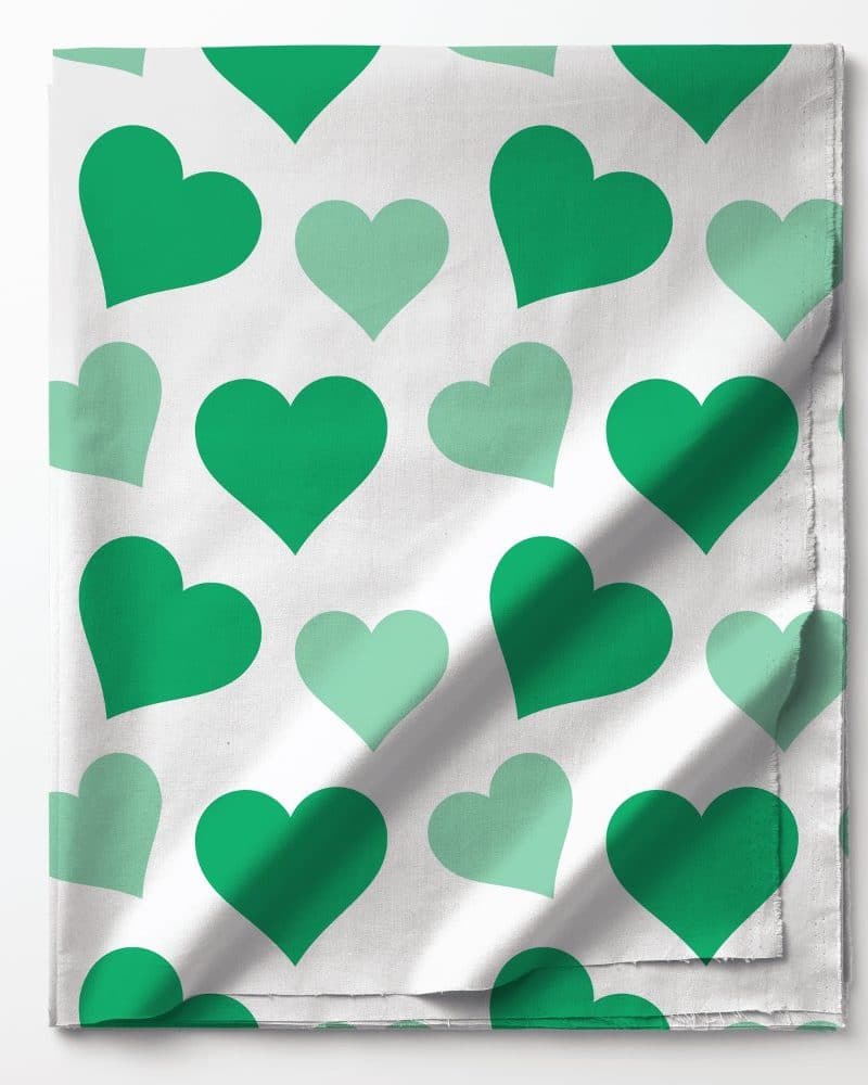 Green and light green hearts on white fabric.