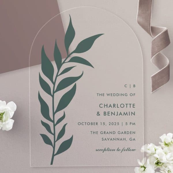 Clear Acrylic Wedding Invitation With A Dark Green Leaf Design And The Names Charlotte And Benjamin.