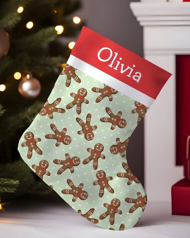 Personalized Christmas stocking with a light green background and a repeating pattern of gingerbread men. The stocking is labeled Olivia.