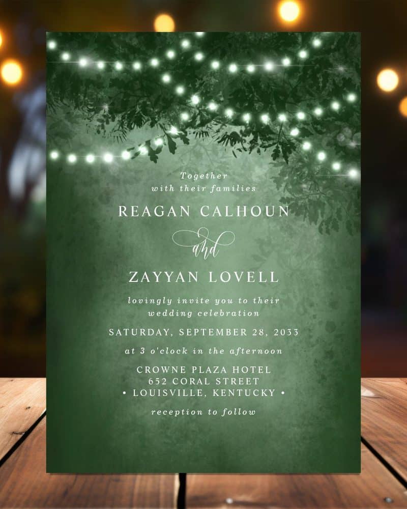 Dark green wedding invitation featuring string lights and leaves, announcing the wedding of Reagan Calhoun and Zayyan Lovell.