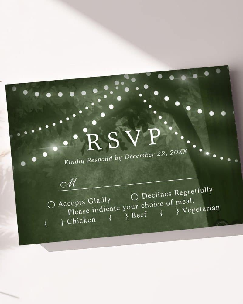 Dark green RSVP card with fairy lights strung around a tree, requesting response by December 22nd, with meal choices.