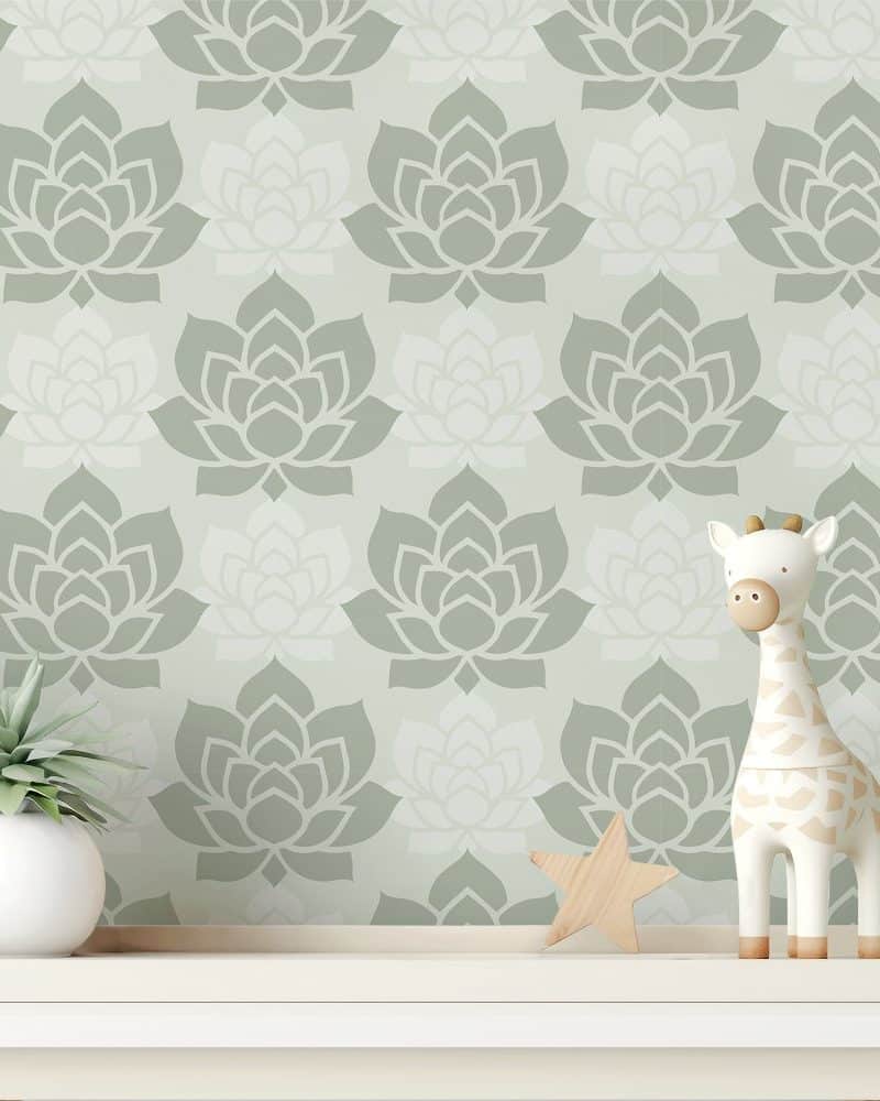 A white wooden shelf holds a small potted plant and a giraffe toy against a wall with a sage green floral wallpaper.