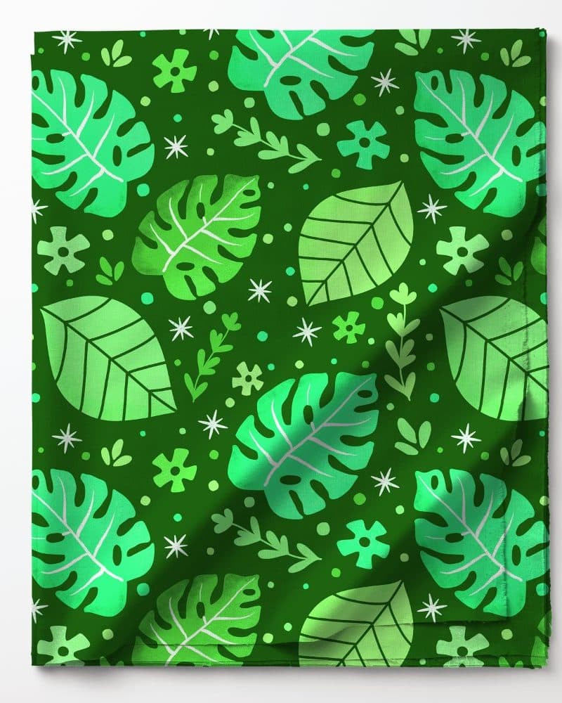 Green fabric with a repeating pattern of monstera leaves and other foliage.