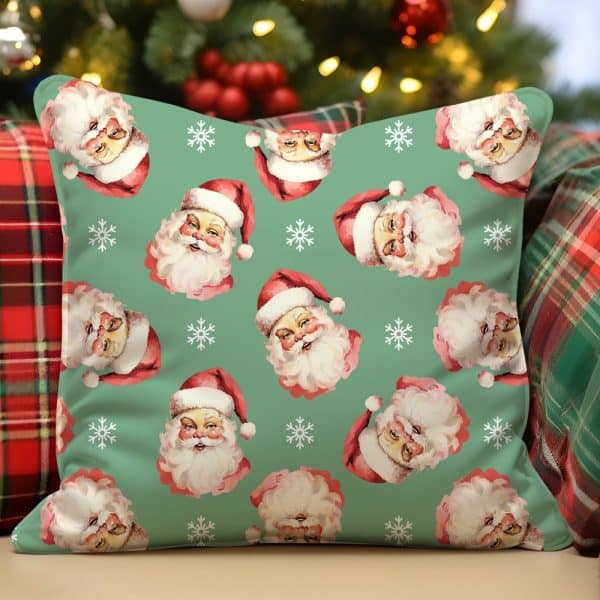 Green Throw Pillow With A Repeating Pattern Of Vintage Santa Claus Faces And Snowflakes.
