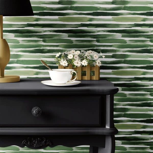 Black Nightstand With A Teacup And Saucer, Small Plant, And Table Lamp Against A Green Watercolor Striped Wall.