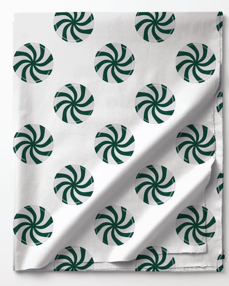 White fabric with a repeating pattern of dark green peppermint candies.