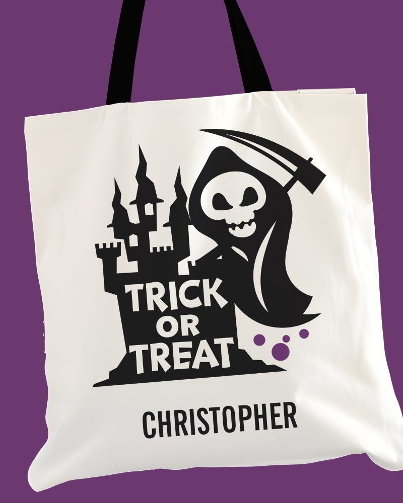 White trick or treat tote bag with a black grim reaper and castle design. The bag is personalized with the name Christopher.