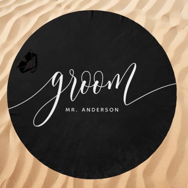 Black Round Beach Towel With The Word Groom And Mr. Anderson In White Script.