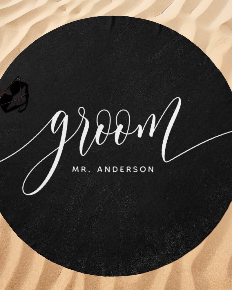 Black round beach towel with the word groom and Mr. Anderson in white script.