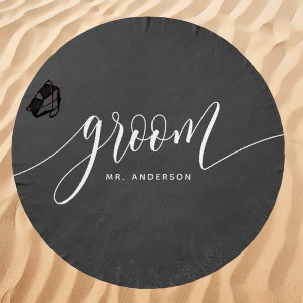 Dark Gray Round Beach Towel With The Word Groom In Elegant White Script And Mr. Anderson Below It.