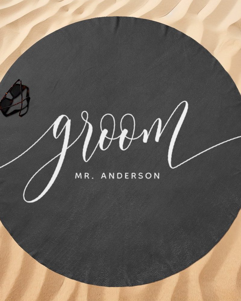 Dark gray round beach towel with the word groom in elegant white script and Mr. Anderson below it.