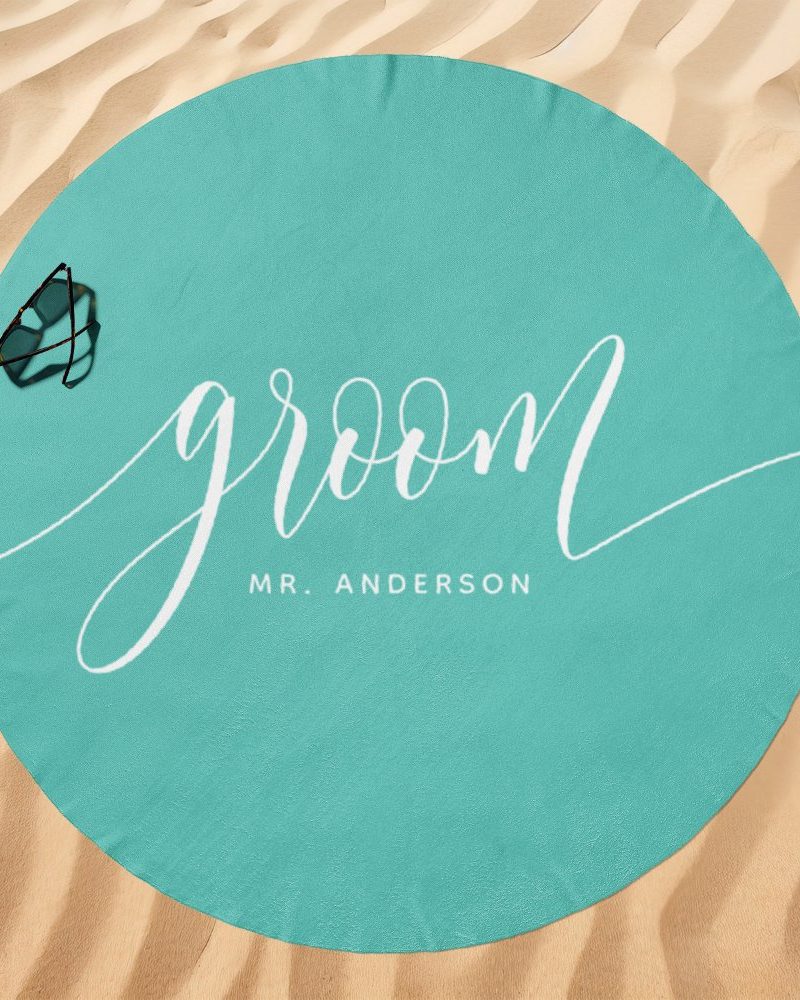 Teal round beach towel with the word groom and Mr. Anderson in white script.