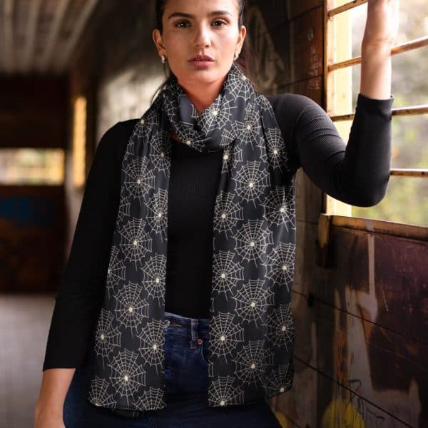 Woman Wearing A Black Scarf With A Cream-Colored Spiderweb Pattern.